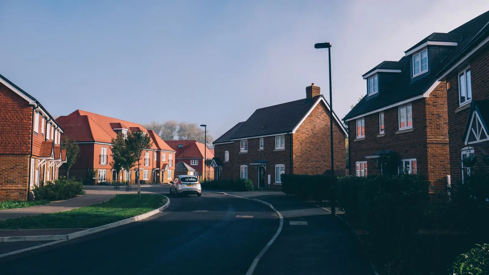 UK new-build housing estate street view — 84-plot residential triple-glazing scheme