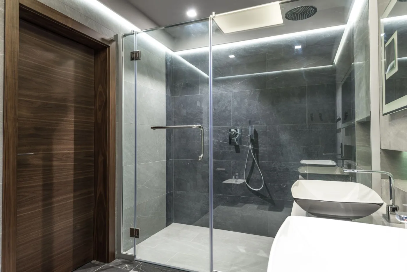 Frameless glass shower screen enclosure in a modern bathroom