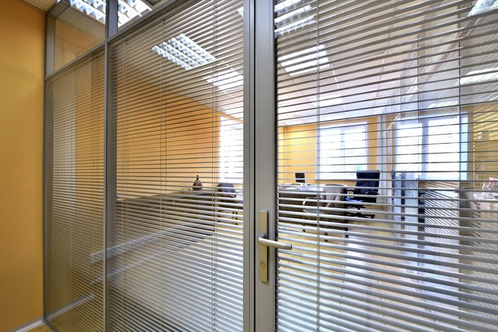 Venetian blinds sealed between the glass panes of aluminium-framed office partition doors