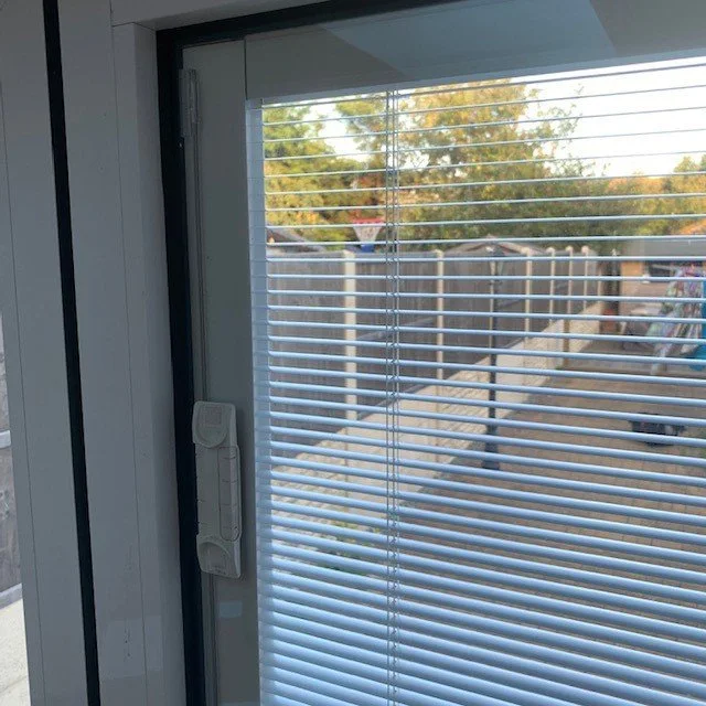 White integral venetian blind inside a sealed glass unit with magnetic slider control on the frame