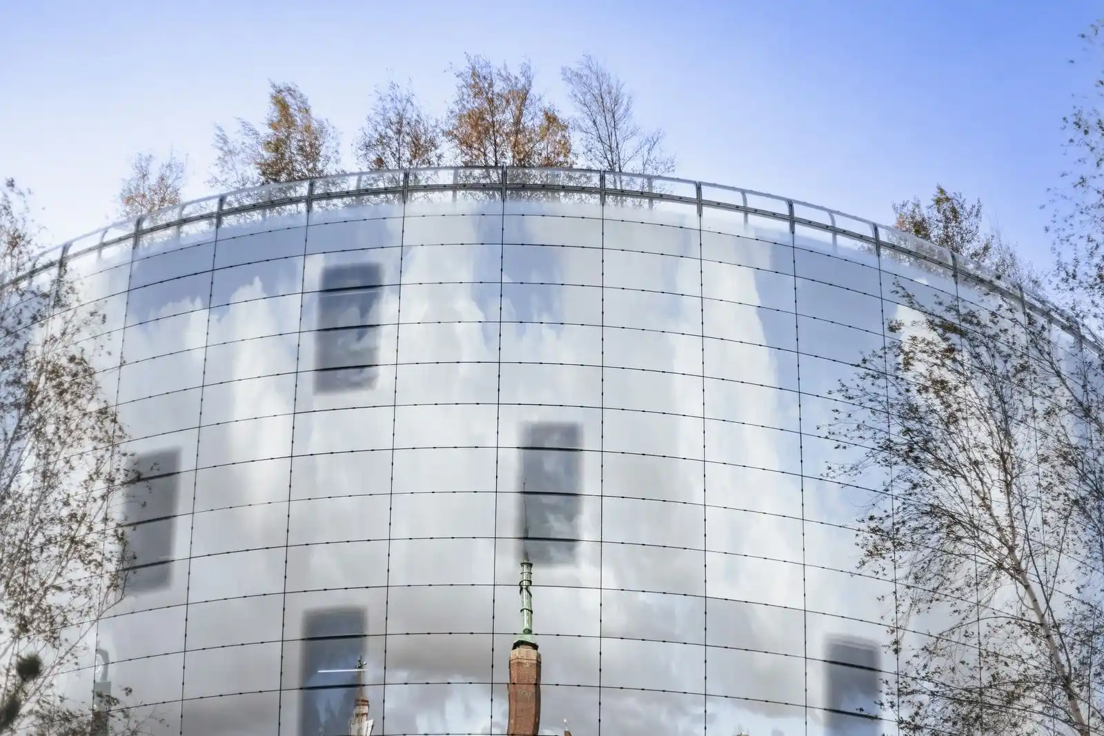 Eco-friendly glass building with trees and reflective facade, sustainable architecture