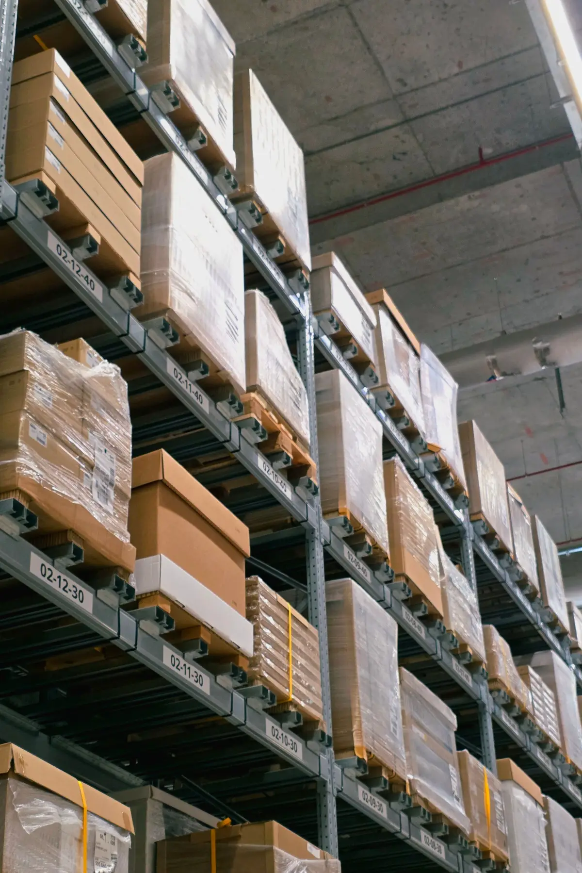 Warehouse pallet racking with plain wrapped boxes and bin location labels