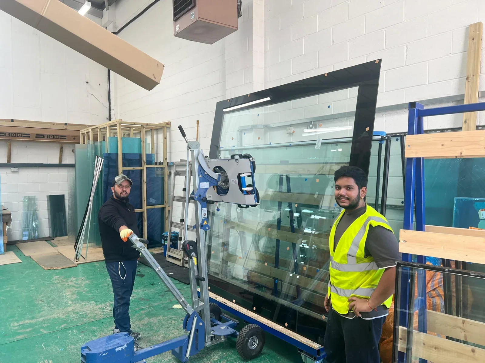 Factory team moving a large stepped unit with a vacuum lifter